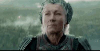 A Close Up Of An Elderly Woman Wearing Armor And Headphones . GIF