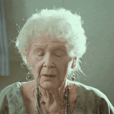 A Close Up Of An Elderly Woman With Her Eyes Closed And A Necklace Around Her Neck GIF