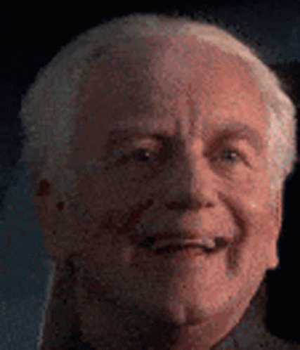 A Close Up Of An Older Man 'S Face With A Blurred Background . GIF