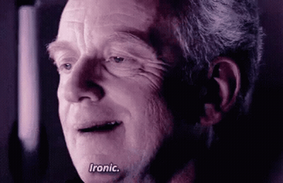 A Close Up Of An Older Man 'S Face With The Words `` Ironic '' Written On His Face . GIF