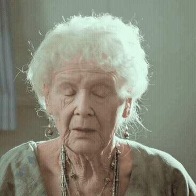 A Close Up Of An Older Woman 'S Face With White Hair GIF