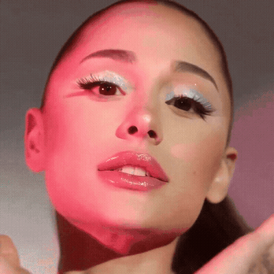 A Close Up Of Ariana Grande 'S Face With Pink And Blue Makeup GIF