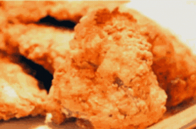 A Close Up Of Fried Chicken Pieces On A Plate GIF