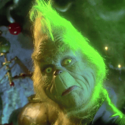 A Close Up Of Grinch 'S Face With Green Hair And Yellow Eyes GIF