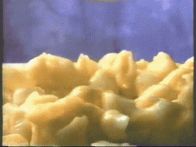 A Close Up Of Macaroni And Cheese Being Cooked In A Microwave . GIF