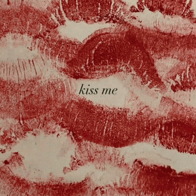 A Close Up Of Red Lips With The Words Kiss Me Written In White GIF