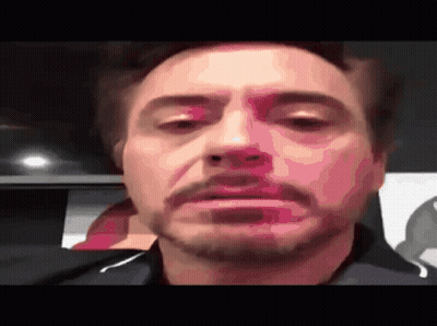 A Close Up Of Robert Downey Jr 'S Face With His Eyes Closed GIF