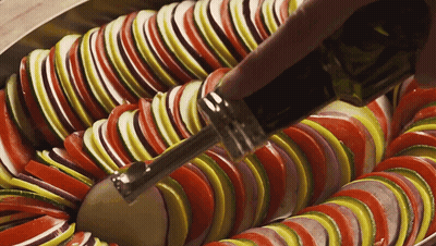 A Close Up Of Sliced Vegetables With A Bottle Of Olive Oil In The Foreground GIF