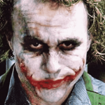 A Close Up Of The Joker 'S Face With A Green Shirt GIF