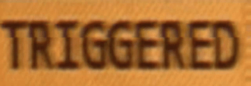A Close Up Of The Word Triggered On A Wooden Surface GIF
