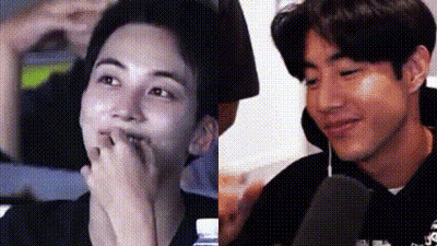 A Close Up Of Two Men 'S Faces , One Covering His Mouth With His Hand . GIF