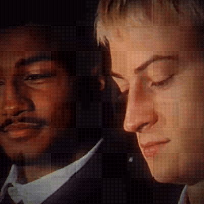 A Close Up Of Two Men 'S Faces With One Wearing A Suit GIF