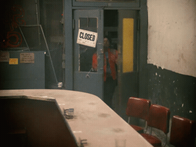 A Closed Sign Hangs On A Door In A Building GIF