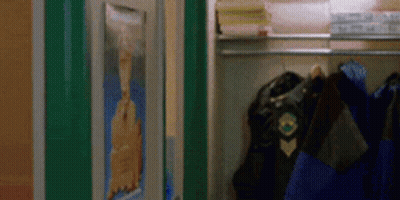 A Closet With A Picture Of A Man On The Wall And A Jacket Hanging On A Rack . GIF
