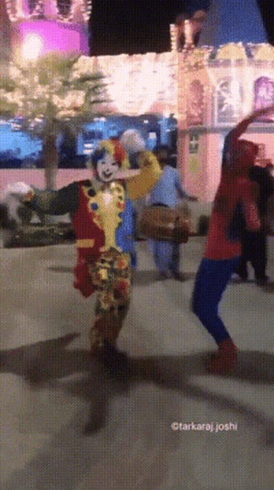 A Clown And A Spiderman Are Dancing In Front Of A Castle GIF