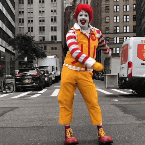 A Clown In A Mcdonald 'S Costume Is Dancing On The Street GIF