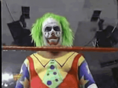 A Clown In A Wrestling Ring With Green Hair And A Tie GIF