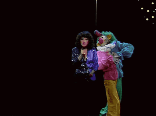 A Clown Is Holding A Woman In A Pink Shirt GIF