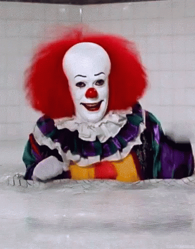 A Clown Is Sitting In A Bathtub With Red Hair And A White Face . GIF