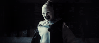 A Clown With His Arms Outstretched Is Wearing A Black And White Costume GIF
