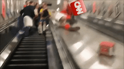 A Cnn Logo Is Flying Over A Group Of People Riding An Escalator GIF