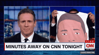 A Cnn News Report Shows A Man Holding A Shirt With A Picture Of A Man On It GIF