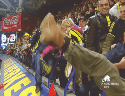 A Coca Cola Sign Hangs Above A Crowd Of Fans GIF