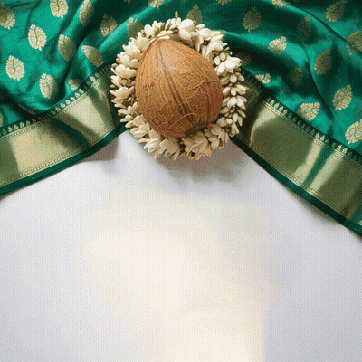 A Coconut Surrounded By White Flowers Sits On A Green Cloth GIF
