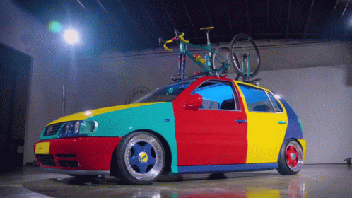 A Colorful Car With A Bike On Top Of It And The Word Costa On The Side GIF