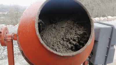 A Concrete Mixer Is Filled With Concrete And Has A Gray Box Behind It GIF