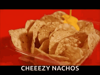 A Container Of Nachos With Cheese Being Poured On Top Of Them . GIF