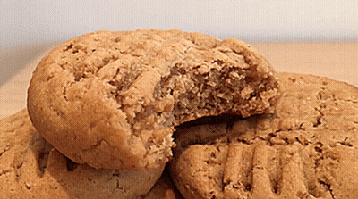 A Cookie With A Bite Taken Out Of It Sits On A Table GIF