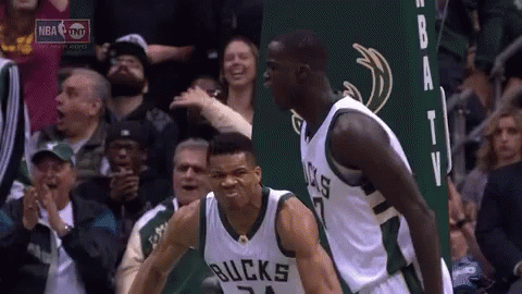 A Couple Of Basketball Players Are Standing Next To Each Other In Front Of A Crowd Of People . GIF
