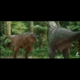 A Couple Of Dinosaurs Are Standing Next To Each Other In The Woods . GIF