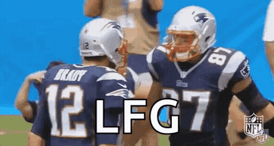 A Couple Of Football Players Are Standing Next To Each Other On The Field . GIF