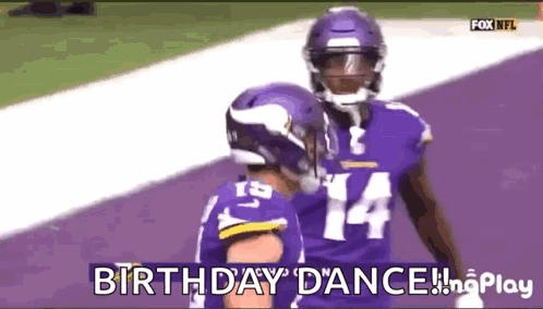 A Couple Of Football Players Are Standing On A Purple Field And One Of Them Is Wearing A Number 14 Jersey . GIF