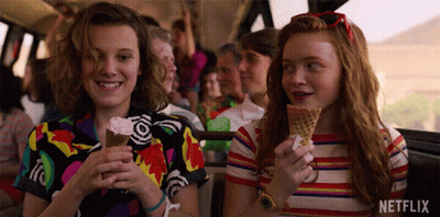 A Couple Of Girls Are Eating Ice Cream Cones On A Bus . GIF