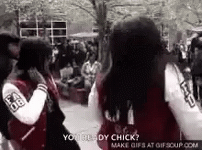 A Couple Of Girls Are Standing Next To Each Other In A Crowded Area . GIF