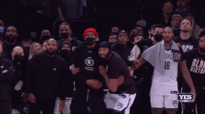 A Couple Of Men Are Hugging Each Other In Front Of A Crowd . GIF