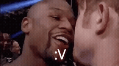 A Couple Of Men Are Kissing Each Other In A Boxing Ring . GIF