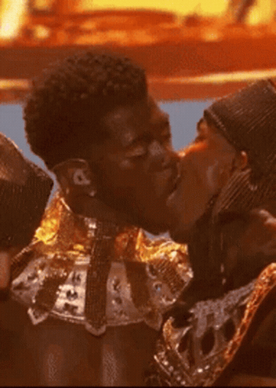 A Couple Of Men Are Kissing Each Other On The Cheek GIF