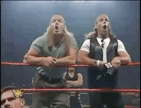 A Couple Of Men Are Standing In A Wrestling Ring . GIF