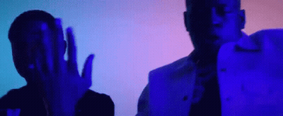 A Couple Of Men Are Standing Next To Each Other In A Dark Room With A Blue Light Behind Them . GIF