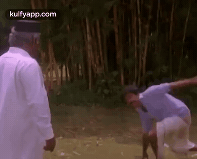 A Couple Of Men Are Standing Next To Each Other In A Field . GIF