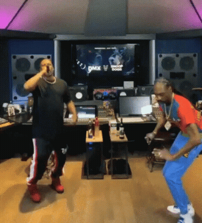 A Couple Of Men Are Standing Next To Each Other In A Room And Dancing . GIF