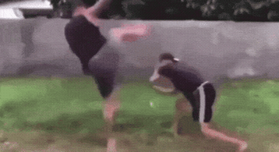 A Couple Of Men Are Standing Next To Each Other In A Yard . GIF