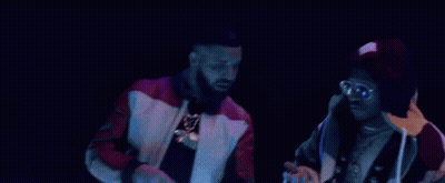 A Couple Of Men Are Standing Next To Each Other On A Stage . GIF