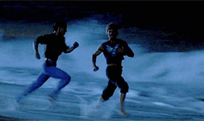 a couple of men running on a beach at night