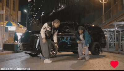 A Couple Of Men Standing Next To A Car With The Number 80 On It GIF