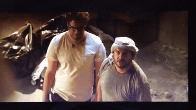 A Couple Of Men Standing Next To Each Other In A Room GIF